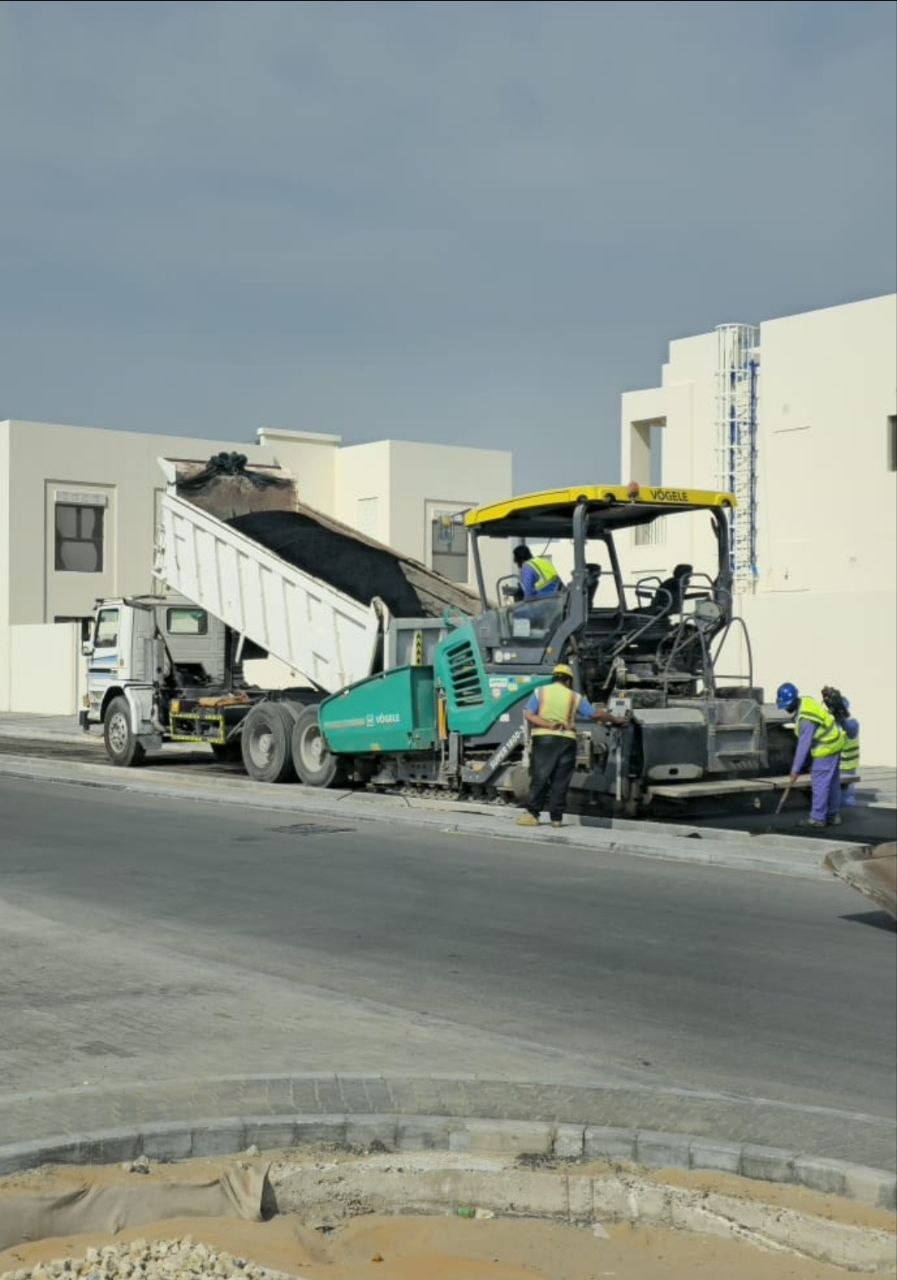 AL RAKAIZ roadworks with an asphalt paving machine and construction crew