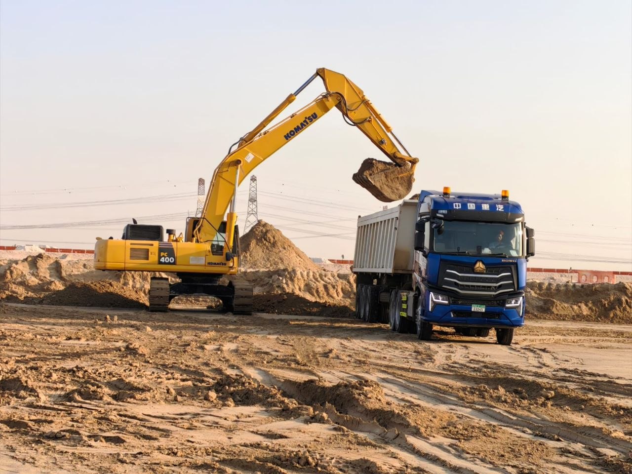 An excavator loading earth into a dump truck